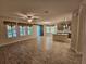 Open living room and kitchen with tile flooring, lots of natural light and a sliding barn door at 16320 Hyde Manor Dr, Tampa, FL 33647