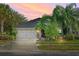 House exterior with two-car garage and landscaped yard at 3001 Silvermill Loop, Land O Lakes, FL 34638