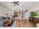 Open living room with hardwood floors, a large TV, and access to a backyard patio at 3001 Silvermill Loop, Land O Lakes, FL 34638