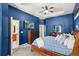 Main bedroom with a large bed, blue walls, and a walk-in closet at 3001 Silvermill Loop, Land O Lakes, FL 34638