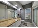 Bathroom with double vanity, large mirror, and walk-in shower at 10301 Manta Way, Tampa, FL 33615