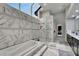 Elegant bathroom with soaking tub, separate shower, and marble tile at 10301 Manta Way, Tampa, FL 33615