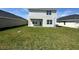 Spacious backyard with green grass and a view of the light colored house at 7002 162Nd E Pl, Parrish, FL 34219