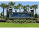 Community entrance sign surrounded by manicured landscaping and palm trees at 7002 162Nd E Pl, Parrish, FL 34219