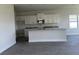Open-concept kitchen featuring an island with granite countertops and white cabinetry at 7002 162Nd E Pl, Parrish, FL 34219