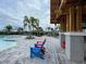 Inviting poolside lounge area with colorful chairs, perfect for relaxation and socializing at 7002 162Nd E Pl, Parrish, FL 34219