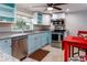 Bright kitchen with light blue cabinets and stainless steel appliances at 12945 Morris Bridge Rd, Thonotosassa, FL 33592