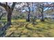 Large backyard with lush grass, mature trees providing shade, and neatly trimmed shrubs at 12945 Morris Bridge Rd, Thonotosassa, FL 33592