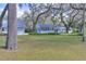 Backyard with mature trees, lush grass, and a small building at 12945 Morris Bridge Rd, Thonotosassa, FL 33592