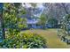 House exterior showcasing light blue siding, landscaping, and large trees at 12945 Morris Bridge Rd, Thonotosassa, FL 33592