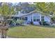Charming ranch home with light blue siding, large windows, and well-maintained landscaping at 12945 Morris Bridge Rd, Thonotosassa, FL 33592