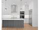 Kitchen features a gray island, white cabinets, stainless steel appliances, and pendant lights at 4005 W San Rafael St, Tampa, FL 33629