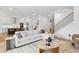 Bright living room with a modern white sofa, open to the kitchen and staircase at 4005 W San Rafael St, Tampa, FL 33629
