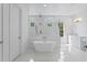 Bright main bathroom with a freestanding tub, walk-in shower, and white marble floors at 4005 W San Rafael St, Tampa, FL 33629