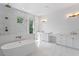 Bright main bathroom with a freestanding tub, walk-in shower, vanity, and marble floors at 4005 W San Rafael St, Tampa, FL 33629