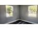 Bright bedroom with two windows and dark gray vinyl flooring at 10008 N Jasmine Ave, Tampa, FL 33612