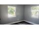 Well-lit bedroom featuring two windows and gray walls at 10008 N Jasmine Ave, Tampa, FL 33612