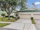 House exterior featuring a two-car garage and green roof at 34841 Double Eagle Ct, Zephyrhills, FL 33541