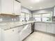 Modern kitchen with white cabinets, granite counters, and stainless steel appliances at 3604 Rockaway Dr, Holiday, FL 34691