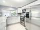 Modern kitchen with white cabinets, granite counters, and stainless steel appliances at 3604 Rockaway Dr, Holiday, FL 34691