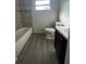 Clean bathroom with a tub, toilet and dark vanity at 7513 Robindale Rd, Tampa, FL 33619