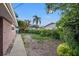 Backyard with a grassy area, pathway, and mature trees at 589 59Th S St, St Petersburg, FL 33707
