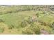 Aerial view of a large property with a house, extensive landscaping, and agricultural fields at 331 Lewis Rd, Lithia, FL 33547