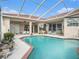 Inviting pool area with covered patio, lush landscaping, and a built-in outdoor kitchen at 331 Lewis Rd, Lithia, FL 33547