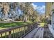 Wooden front porch overlooking a spacious yard with mature trees at 331 Lewis Rd, Lithia, FL 33547