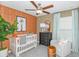Charming Bedroom featuring an orange accent wall and crib at 11294 Linden Depot Rd, San Antonio, FL 33576