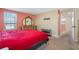 Bright bedroom featuring a red comforter and ensuite access at 602 Olive Conch St, Ruskin, FL 33570