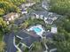 Aerial view showing apartment buildings, pool, and surrounding trees at 5125 Palm Springs Blvd # 9302, Tampa, FL 33647