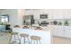 Modern kitchen with island, white cabinets, and stainless steel appliances at 2530 Leonia Ln, Zephyrhills, FL 33541