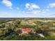 Aerial view of a home with pool, red roof, and expansive grounds at 11623 Innfields Dr, Odessa, FL 33556