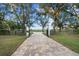 Brick-paved driveway leading through lush landscaping to a grand estate at 11623 Innfields Dr, Odessa, FL 33556