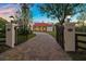 Grand entrance with wrought iron gates and a paved driveway at 11623 Innfields Dr, Odessa, FL 33556