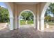 Archway view of a tranquil fountain and pond at 11623 Innfields Dr, Odessa, FL 33556