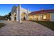 Elegant home exterior at dusk, showcasing brick pavers and arched entryway at 11623 Innfields Dr, Odessa, FL 33556