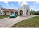 Grand entrance to a luxurious home, with a green car parked on the driveway at 11623 Innfields Dr, Odessa, FL 33556