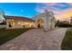 Elegant home with arched entryway and a brick-paved driveway at 11623 Innfields Dr, Odessa, FL 33556