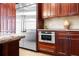Stainless steel appliances are built into rich wood cabinetry in this kitchen at 11623 Innfields Dr, Odessa, FL 33556