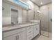 Modern bathroom with double vanity, large shower, and grey tile at 11217 Livewell Ct, Venice, FL 34293