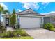 New home exterior with white garage door and light blue siding at 11217 Livewell Ct, Venice, FL 34293