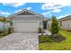 Exterior of a single story house with gray siding, white garage door, and landscaped yard at 11223 Livewell Ct, Venice, FL 34293