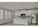 Modern kitchen features white cabinets, stainless steel appliances, and an island at 11223 Livewell Ct, Venice, FL 34293