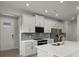 Modern kitchen featuring white cabinets, stainless steel appliances, and a large island at 11223 Livewell Ct, Venice, FL 34293