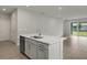 Kitchen island with sink and stainless steel dishwasher, opening to living area at 11223 Livewell Ct, Venice, FL 34293