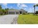 Two-story house with gray siding, paver driveway, and landscaped lawn at 14350 Allensworth Ave, Port Charlotte, FL 33981