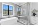 Bright bathroom with freestanding tub, glass shower and white cabinets at 5032 W Longfellow Ave, Tampa, FL 33629