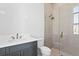 Modern bathroom featuring a glass shower with brushed gold fixtures and a blue vanity at 5032 W Longfellow Ave, Tampa, FL 33629